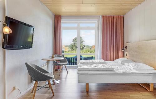 een slaapkamer met een bed en een tv aan de muur bij Stunning Apartment In Allinge With Kitchen in Allinge