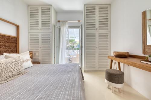 a bedroom with white walls and a bed and a window at Amalgam Homes Paros in Ambelas