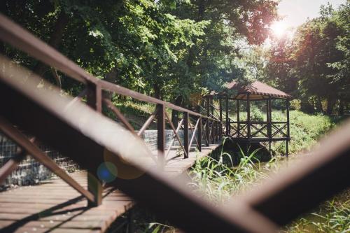a wooden bridge with a gazebo in a park at Lake Park in Novomoskovsʼk