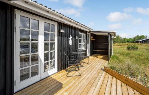 a deck with a table and chairs on a house at Holiday Home Lyngbakken Fanø Denm in Fanø