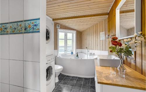 a bathroom with a tub sink and a washing machine at Nice Home In Fan With Wifi in Fanø