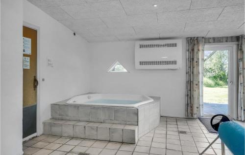 Habitación con baño grande con bañera. en Lovely Home In Blvand With Indoor Swimming Pool, en Blåvand