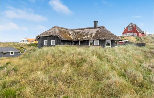 an old house with a thatched roof on a hill at Nice Home In Vejers Strand With Wifi in Vejers Strand
