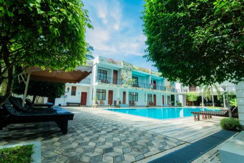 a hotel with a swimming pool and trees at Royal Reach Udawalawe in Udawalawe