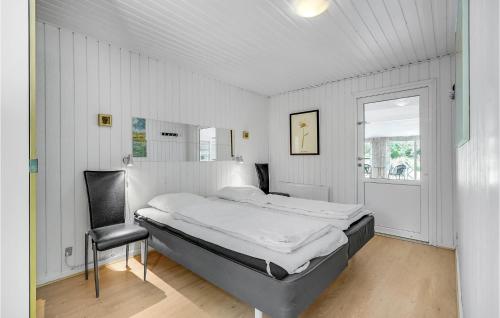 1 dormitorio con 1 cama y 1 silla en Lovely Home In Blvand With Indoor Swimming Pool, en Blåvand