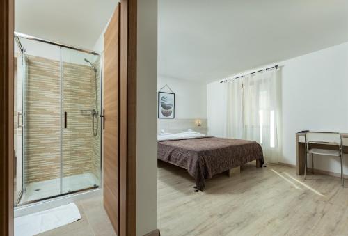 - une chambre avec un lit et une douche en verre dans l'établissement Villa Borgo B&B, à Motovun