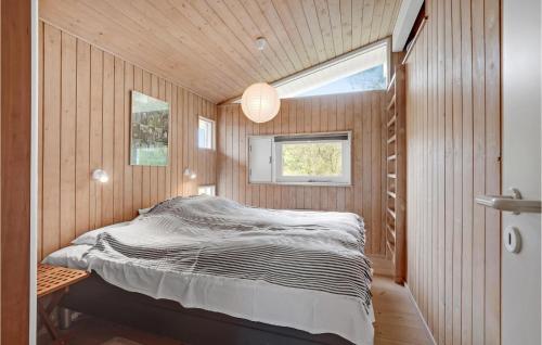 SønderhoにあるAmazing Home In Fan With Wifiの窓付きの木造の部屋のベッド1台