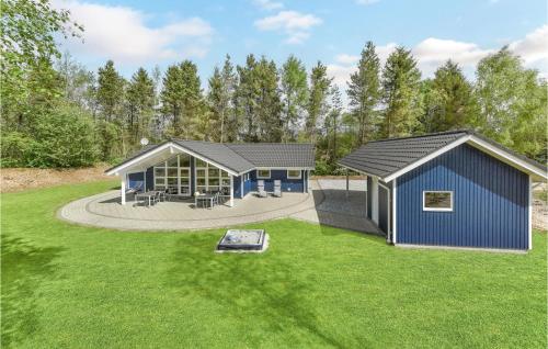 a home with a blue building in a yard at Holiday Home Hybenvangen Oksbøl Denm in Oksbøl