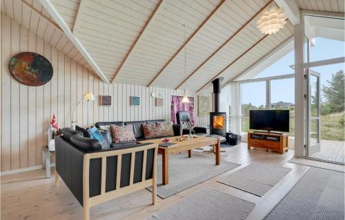 a living room with a couch and a tv at Holiday Home Lyngen in Søndervig