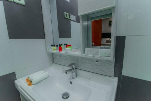 une salle de bain avec un lavabo et un miroir dans l'établissement Royal Reach Udawalawe, à Uda Walawe