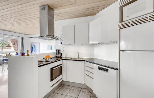 a kitchen with white cabinets and a refrigerator at Holiday Home Lyngvejen Rømø V in Rømø Kirkeby