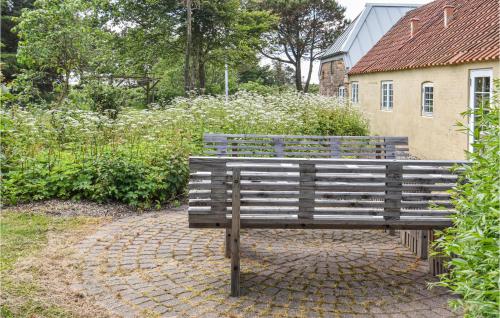 a wooden bench sitting on a brick walk way at Holiday Home Tyttebærvej Ulfborg Xii in Sundhuse