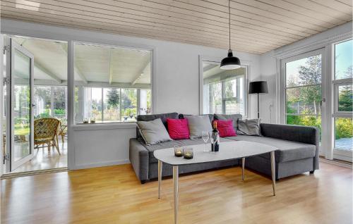 a living room with a couch and a table at Holiday Home Sølvpoppelvej Væggerløse Vi in Marielyst