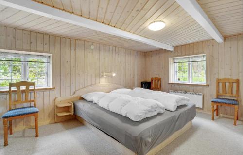 Sundhuseにある7 Bedroom Nice Home In Ulfborgのベッドルーム1室(大型ベッド1台、椅子2脚付)