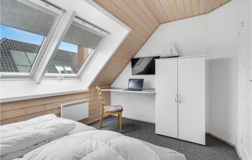 HavnebyにあるAmazing Home In Rm With 3 Bedrooms, Sauna And Wifiの屋根裏のベッドルーム(ベッド1台、デスク、窓付)