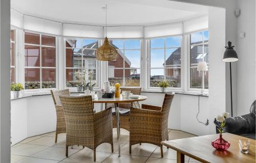 a dining room with a table and chairs and windows at Three-Bedroom Holiday Home In Romo in Havneby