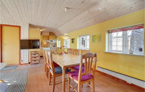 a kitchen and dining room with a table and chairs at Holiday Home Tyttebærvej Ulfborg Xii in Sundhuse
