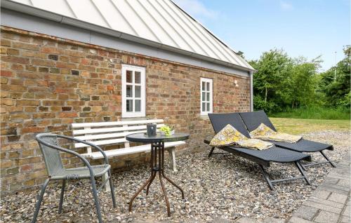 a patio with two chairs and a table and a bench at Holiday Home Tyttebærvej Ulfborg Xii in Sundhuse