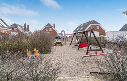 a playground with a swing set in the sand at Three-Bedroom Holiday Home In Romo in Havneby