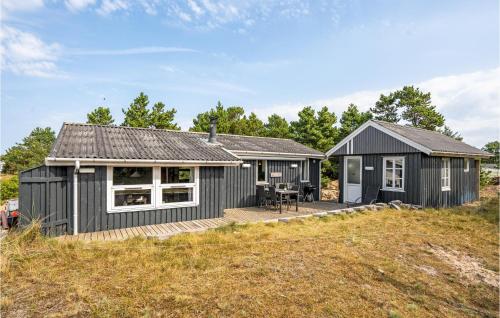 a black cottage with a deck and a house at Holiday Home Vester Kirketoft Fanø Ix in Fanø