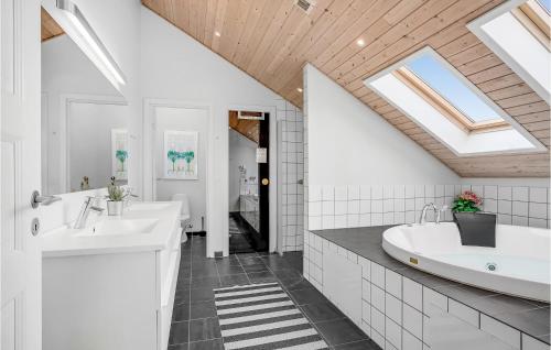 La salle de bains est pourvue de 2 lavabos et d'une baignoire. dans l'établissement Cozy Home In Fan With Sauna, à Sønderho