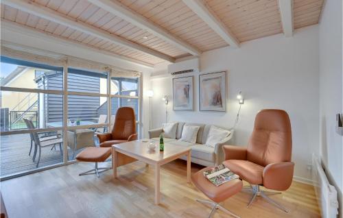 a living room with a couch and chairs and a table at Hus R in Henne Strand