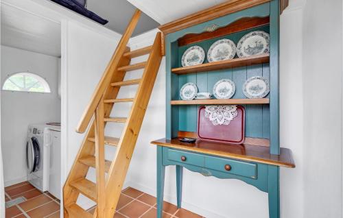 a blue cabinet with plates on it next to a staircase at Stunning Home In Rm With 2 Bedrooms And Wifi in Bolilmark