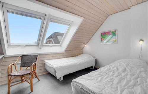 a bedroom with a bed and a chair and a window at Holiday Home Sdr Frankel Xi in Rømø Kirkeby