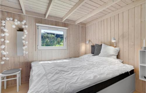 a bedroom with a bed and a window at Stunning Home In Blokhus With 3 Bedrooms, Sauna And Wifi in Blokhus