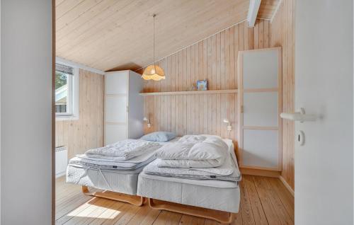ÅlbækにあるStunning Home In lbk With Wifiの木製の壁のベッドルーム1室(ベッド2台付)