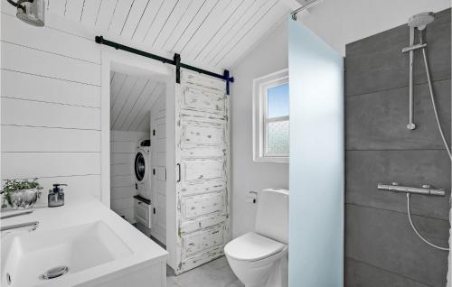 a white bathroom with a toilet and a sink at Beautiful Home In Thisted With 2 Bedrooms And Wifi in Nørre Vorupør