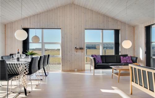 a living room with a table and chairs at 5 Bedroom Pet Friendly Home In Løkken in Løkken
