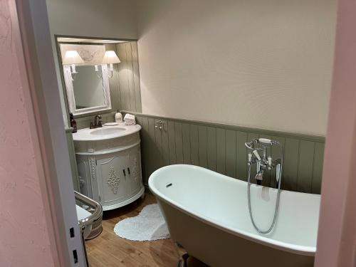 a bathroom with a bath tub and a sink at Bri22 -lanvallay - La Petite Madeleine in Dinan