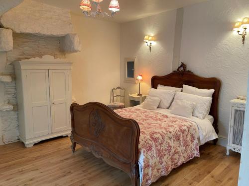 a bedroom with a large bed and a fireplace at Bri22 -lanvallay - La Petite Madeleine in Dinan