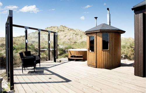 a wooden deck with a gazebo and a chair at Studio Holiday Home In Lokken in Løkken