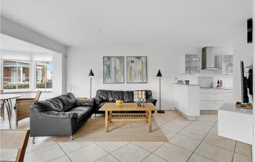 a living room with a black leather couch and a table at Three-Bedroom Holiday Home In Romo in Havneby