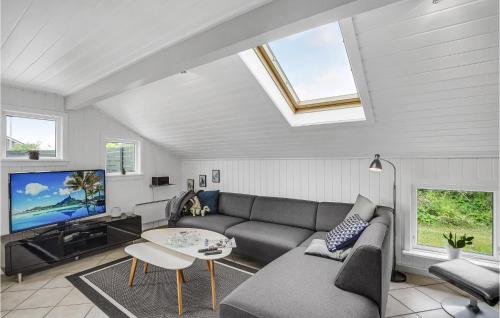 a living room with a couch and a tv at Holiday Home Fiskervej Thisted Iv in Thisted