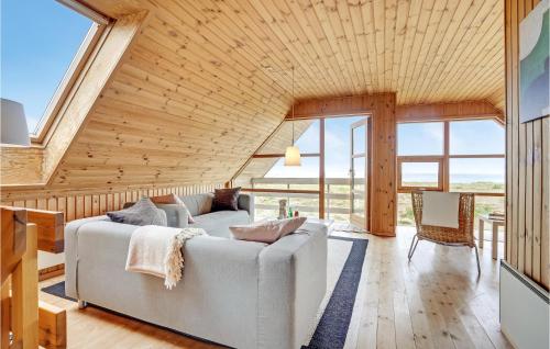 a living room with a white couch and wood ceilings at Awesome Home In Læsø With Kitchen in Læsø