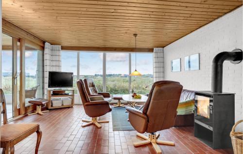 Una sala de estar con dos sillas y una chimenea. en Nice Home In Thisted With Sauna, en Thisted