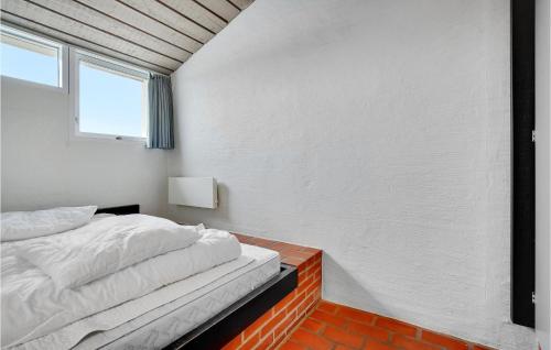 ein weißes Schlafzimmer mit einem Bett und einem Fenster in der Unterkunft Feriehotel Tranum Klit in Brovst