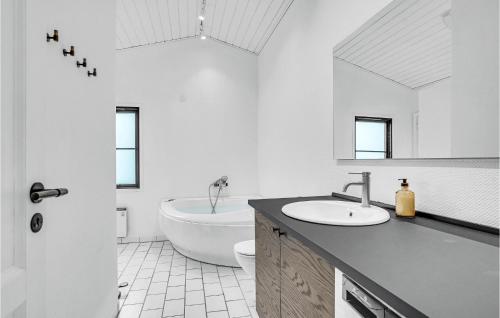 a bathroom with a sink and a tub and a toilet at Amazing Home In lbk With 3 Bedrooms, Sauna And Wifi in Ålbæk