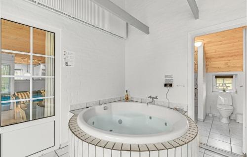 HusbyにあるAwesome Home In Ulfborg With Saunaの白い大きなバスルーム(大型バスタブ付)