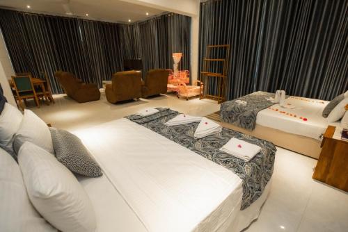 pokój hotelowy z 2 łóżkami i salonem w obiekcie Royal Reach Udawalawe w mieście Udawalawe