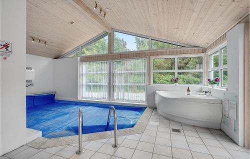 a bathroom with a tub and a large window at Cozy Home In Jerup With Kitchen in Jerup