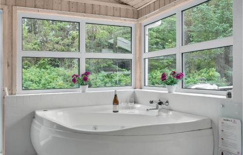 a white bathroom with a sink and four windows at Cozy Home In Jerup With Kitchen in Jerup