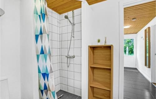 La salle de bains est pourvue d'une douche avec un rideau de douche bleu et blanc. dans l'établissement Cozy Home In ster Assels With Sauna, à Øster Assels