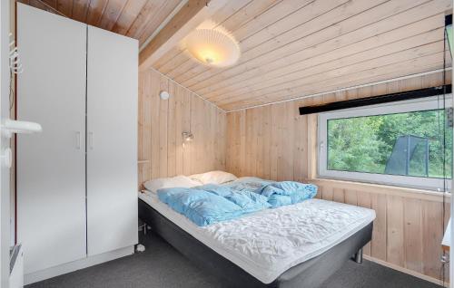 a bed in a small room with a window at Cozy Home In Jerup With Kitchen in Jerup