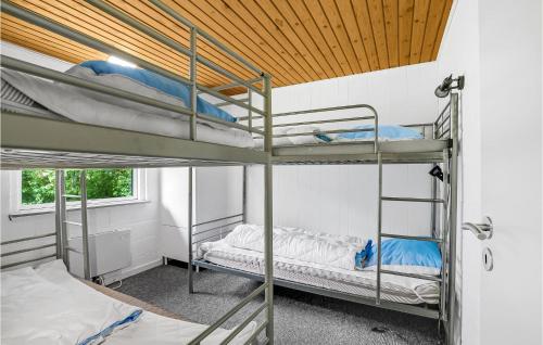 Cette chambre comprend 2 lits superposés et un plafond en bois. dans l'établissement Cozy Home In ster Assels With Sauna, à Øster Assels