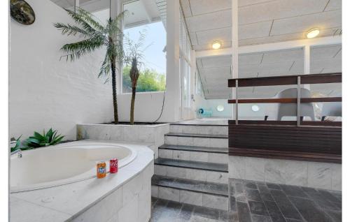 格林哥里的住宿－亞霍恩維杰洛斯弗九世度假屋，带浴缸的浴室和棕榈树。