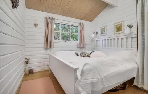 StrandbyにあるBeautiful Home In Strandby With 2 Bedrooms And Wifiの白い壁のベッドルーム1室、窓付きのベッド1台が備わります。